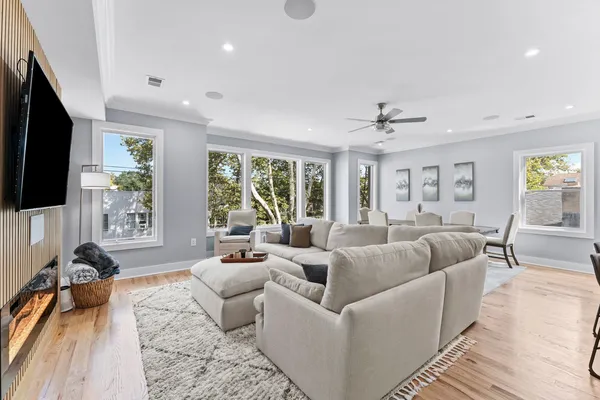 a living room with furniture a flat screen tv and a large window