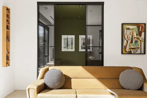 a living room with a couch and painting on the wall