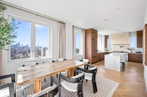 a dining room with furniture a large window and wooden floor
