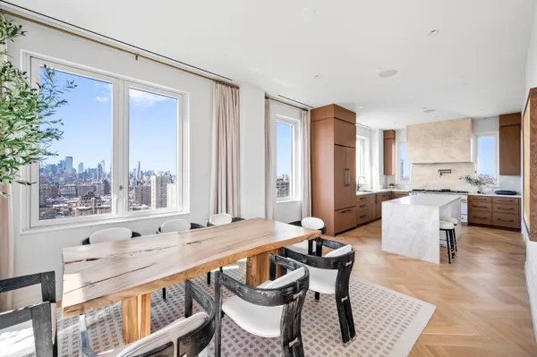 a dining room with furniture a large window and wooden floor