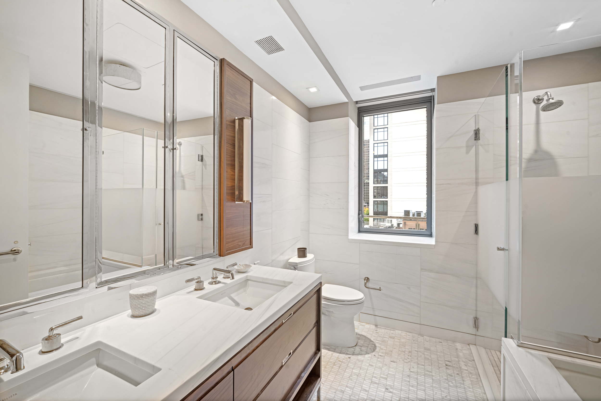 301 East 50th Street, Unit 5A Manhattan, NY 10022 - Photo 7 of 19 a bathroom with a tub sink toilet and mirror