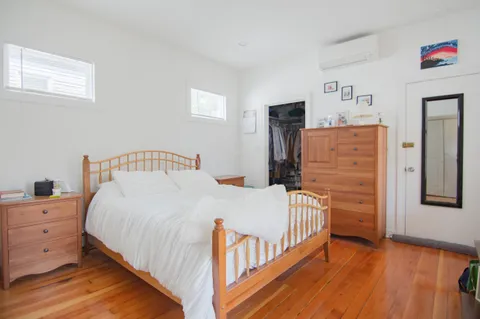 a bedroom with a bed and wooden floor