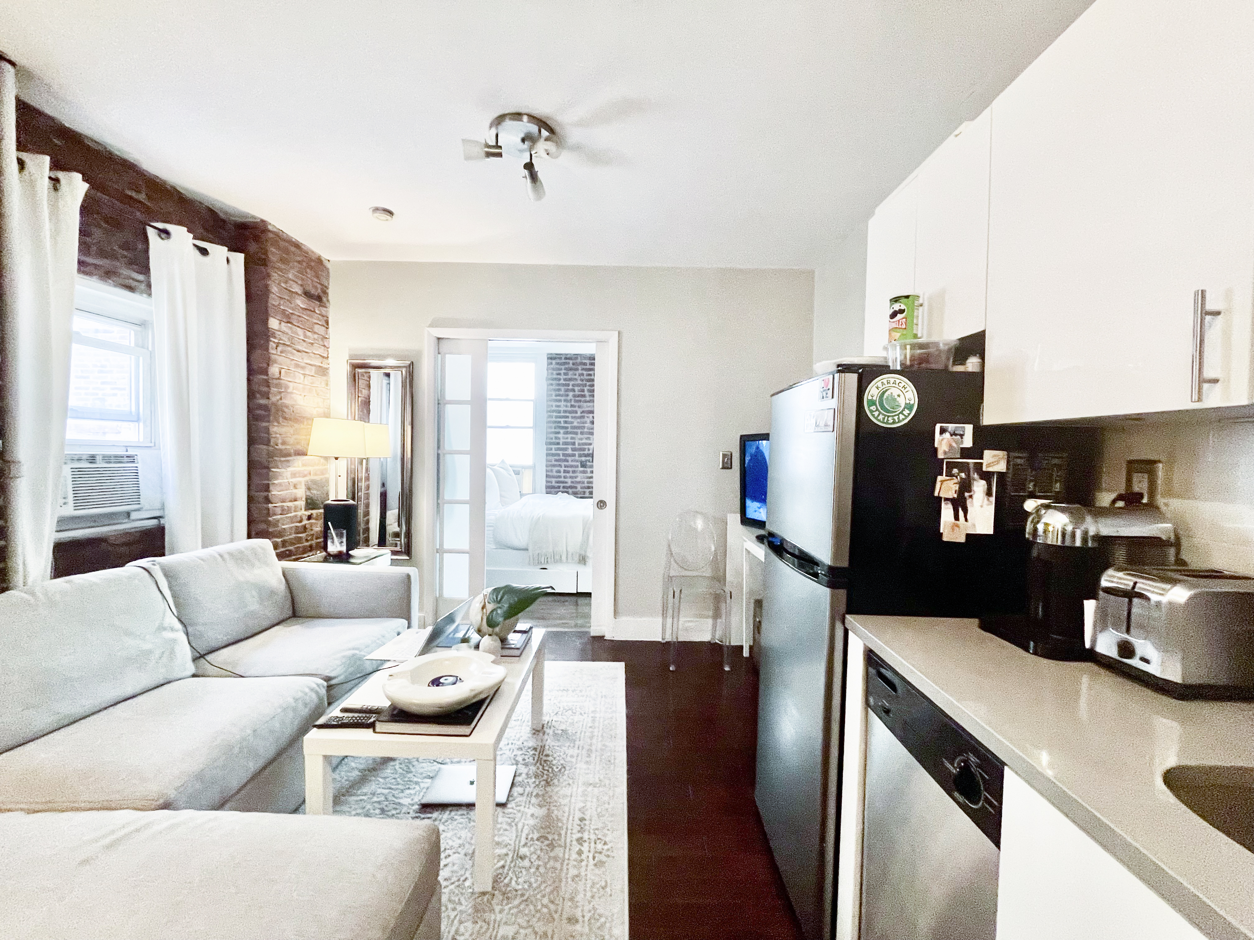 57 Spring Street, Unit 6 Manhattan, NY 10012 - Photo 8 of 10 a living room with furniture and a flat screen tv