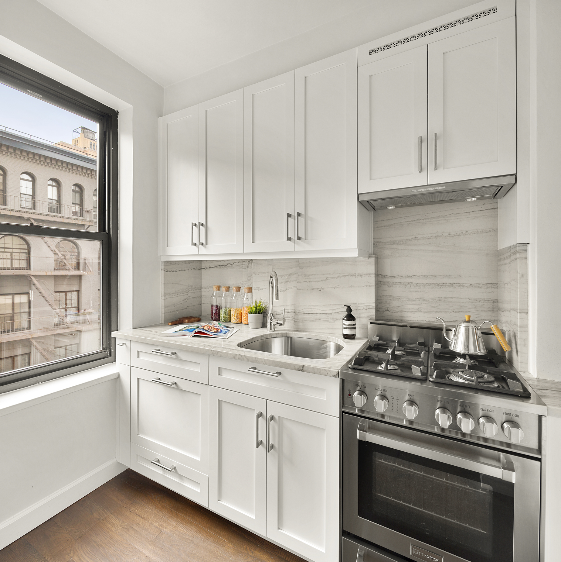 161 West 16th Street, Unit 6E Manhattan, NY 10011 - Photo 3 of 15 a kitchen with cabinets appliances a sink and a window