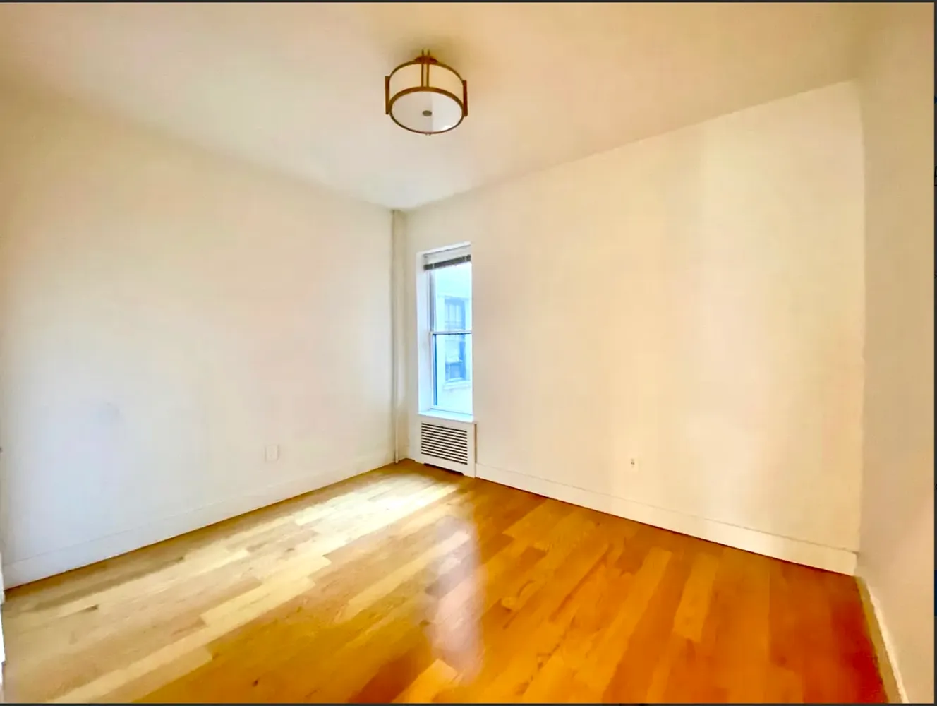 a view of a room with wooden floor and white walls