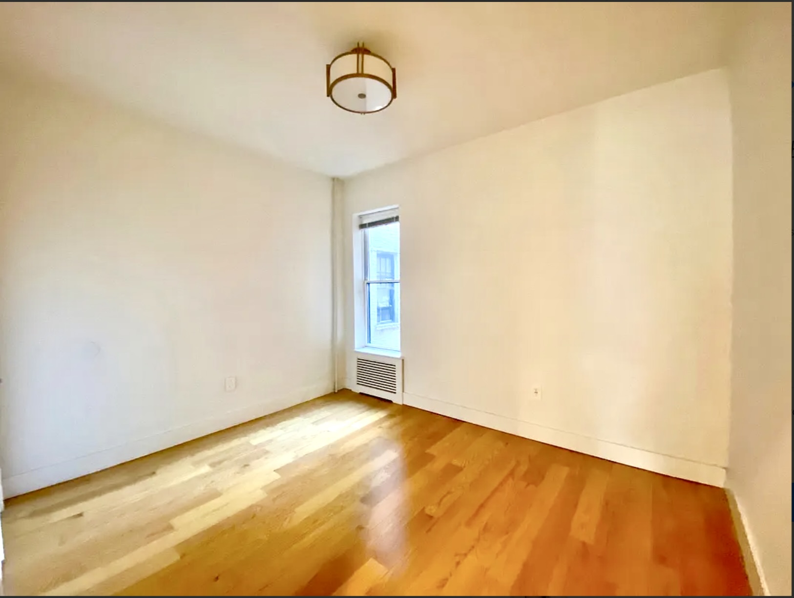 211 8th Avenue, Unit 1C Brooklyn, NY 11215 - Photo 6 of 11 a view of a room with wooden floor and white walls