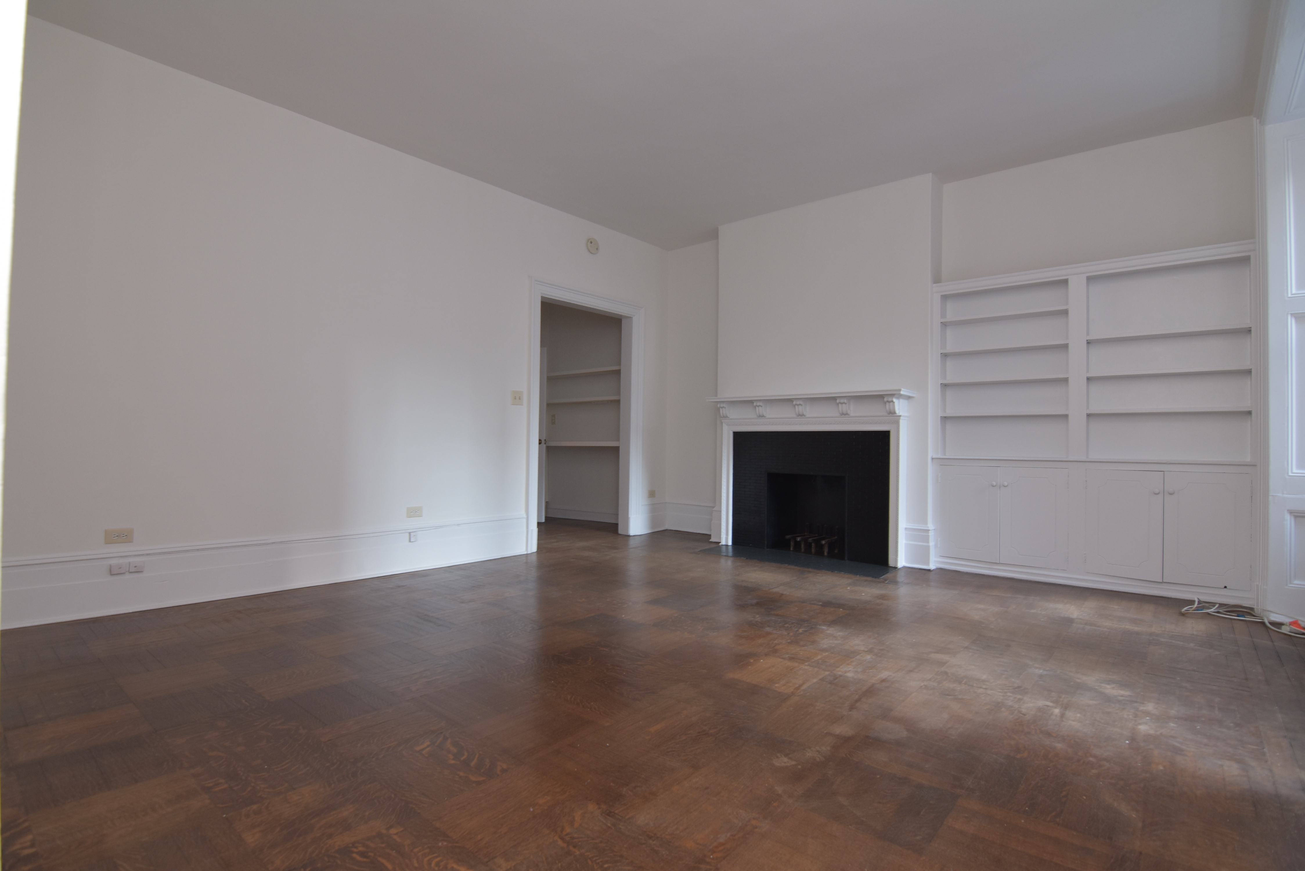 18 East 67th Street, Unit 2B/3B Manhattan, NY 10065 - Photo 16 of 18 an empty room with a fireplace and cabinet