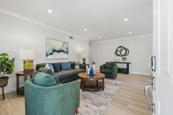a living room with furniture and a wooden floor