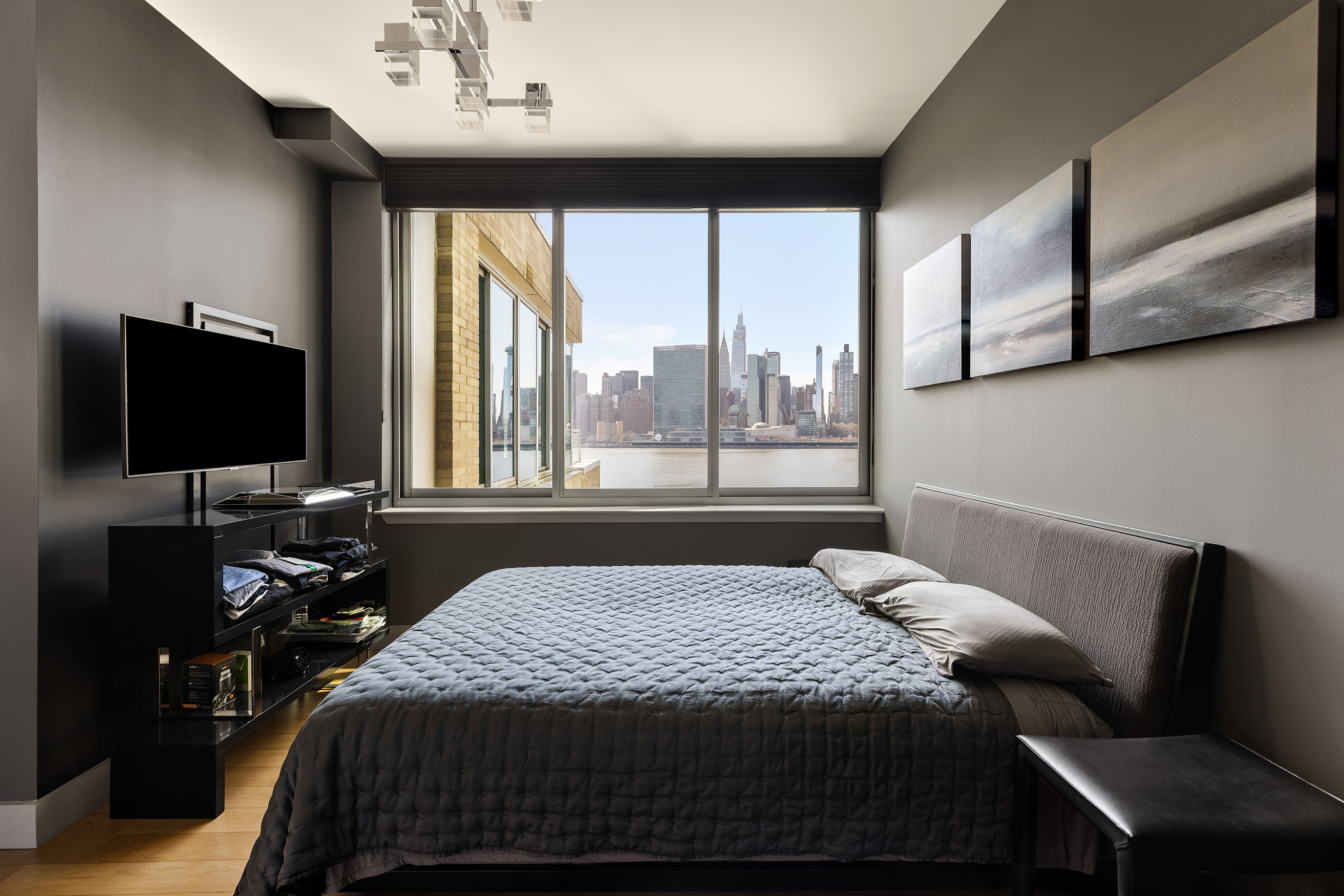 46-30 Center Boulevard, Unit 610 Queens, NY 11109 - Photo 8 of 19 a bedroom with a large bed and a flat tv screen on dresser