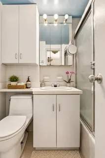 a bathroom with a sink a toilet and mirror