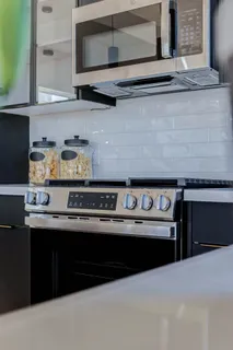 a kitchen with stainless steel appliances granite countertop a stove and a microwave