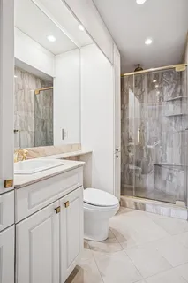 a bathroom with a granite countertop sink a toilet and shower