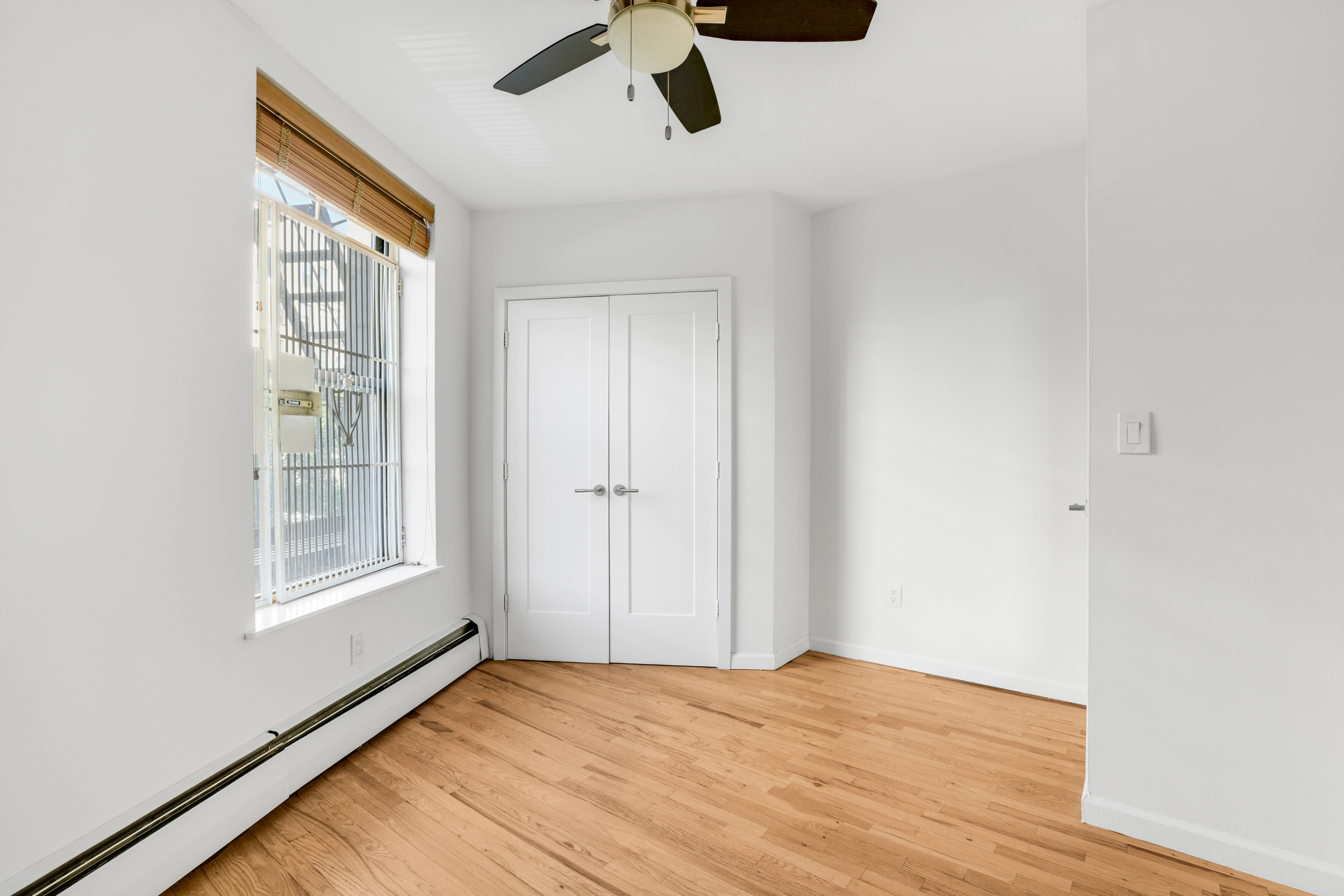 66-72 St Nicholas Avenue, Unit 3G Manhattan, NY 10026 - Photo 11 of 15 a view of an empty room with a window and wooden floor