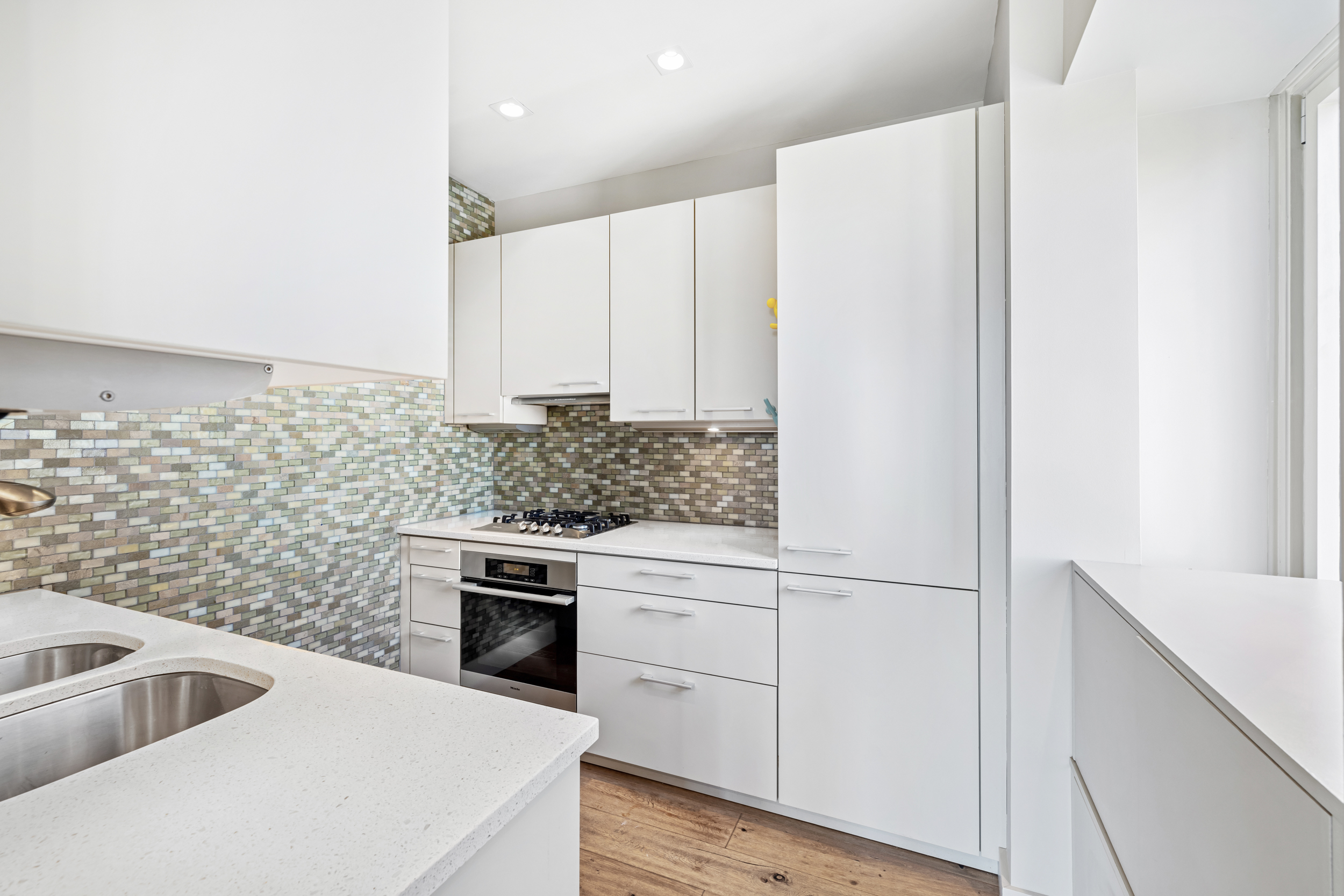 150 West 56th Street, Unit 4802 Manhattan, NY 10019 - Photo 3 of 13 a kitchen with a sink cabinets and stainless steel appliances