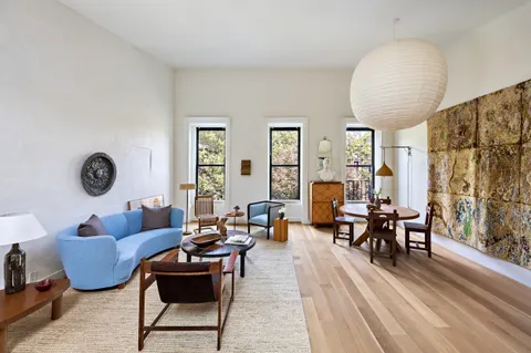 a living room with furniture kitchen view and a large window