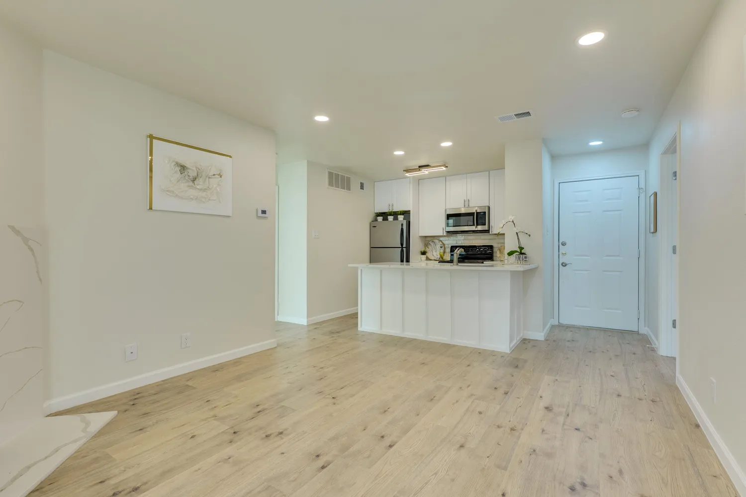 a kitchen with kitchen island a white counter top space cabinets and stainless steel appliances
