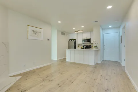 a kitchen with kitchen island a white counter top space cabinets and stainless steel appliances