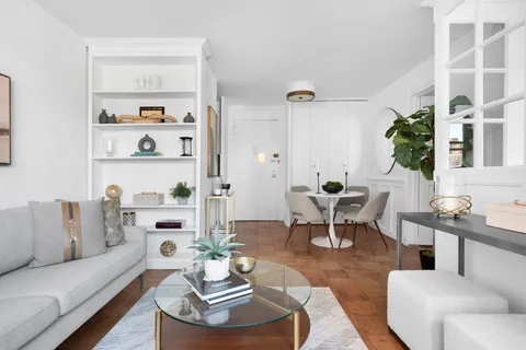 a living room with furniture a rug and a table