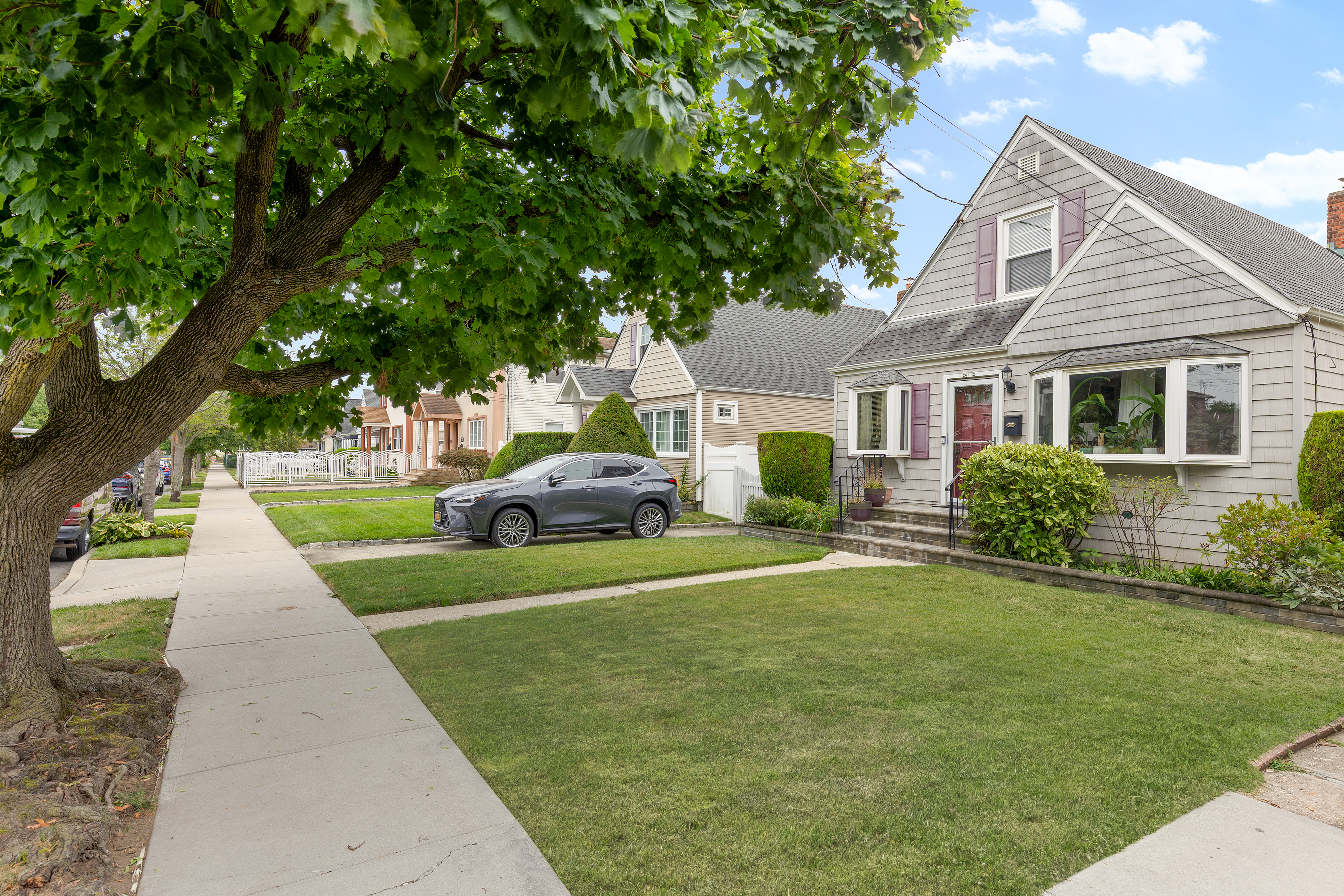 241-12 148th Avenue Queens, NY 11422 - Photo 2 of 15 a front view of a house with a yard and trees