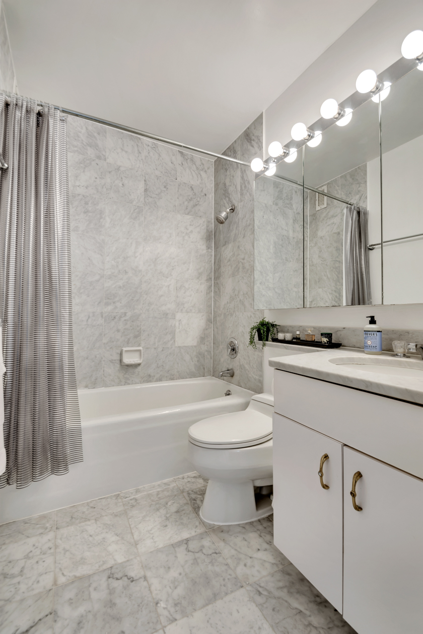 235 East 40th Street, Unit 11G Manhattan, NY 10016 - Photo 8 of 20 a bathroom with a sink a toilet and a bathtub