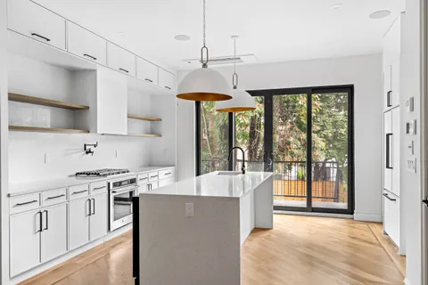 a large kitchen with kitchen island a large counter top space a sink stainless steel appliances and cabinets