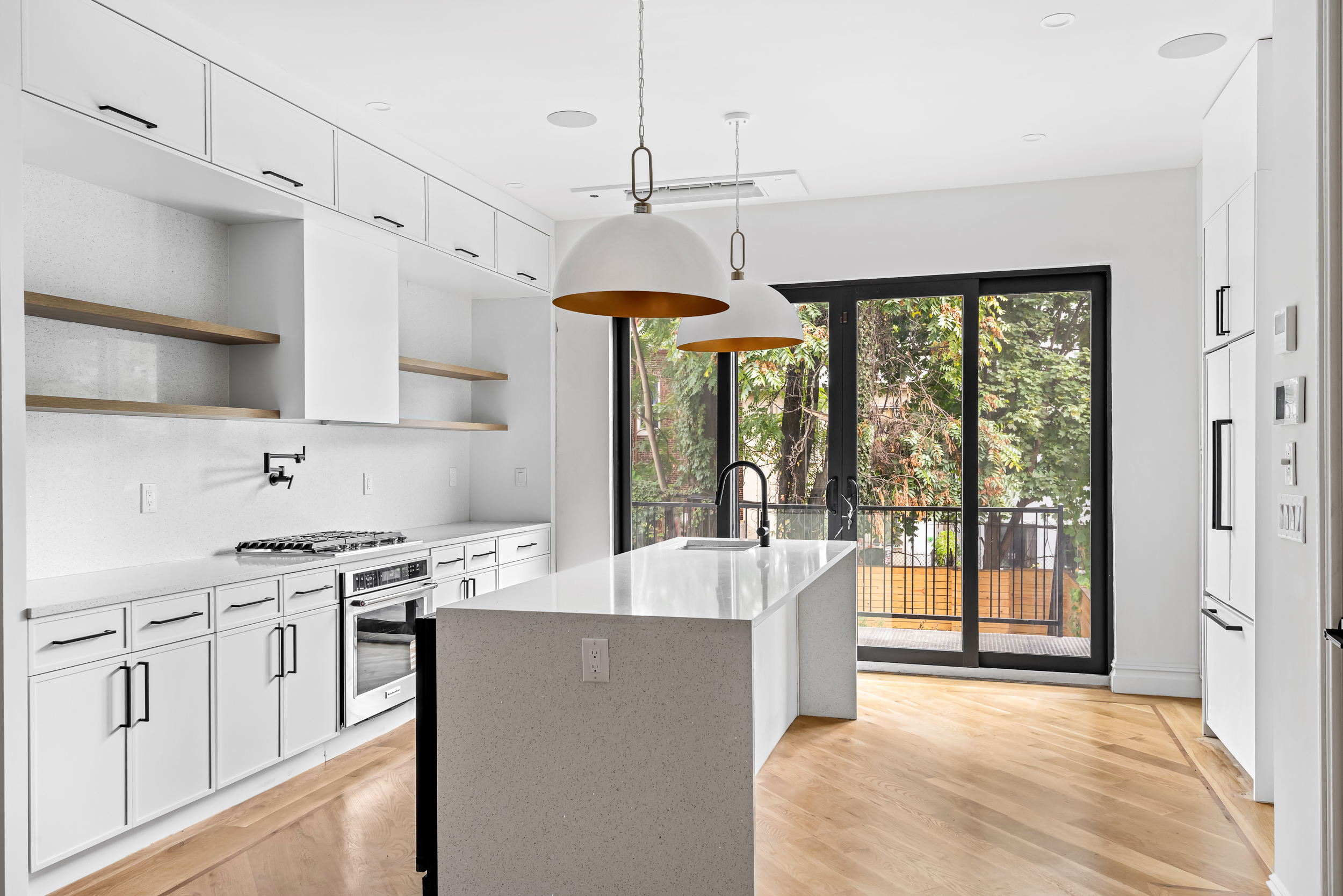 608 Van Buren Street Brooklyn, NY 11221 - Photo 1 of 10 a large kitchen with kitchen island a large counter top space a sink stainless steel appliances and cabinets