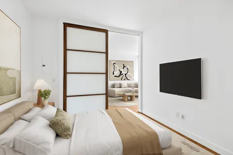 a bedroom with a bed and a flat screen tv