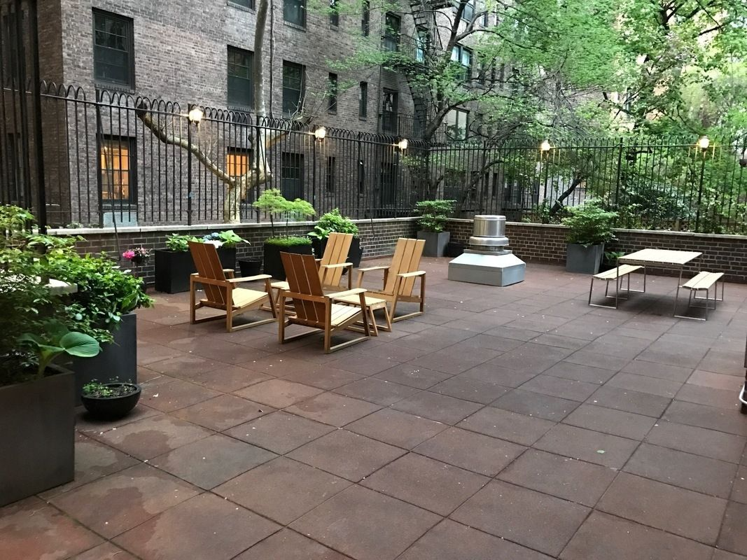 12 Beekman Place, Unit 7/8B Manhattan, NY 10022 - Photo 12 of 17 a view of a patio with table and chairs potted plants and a large tree