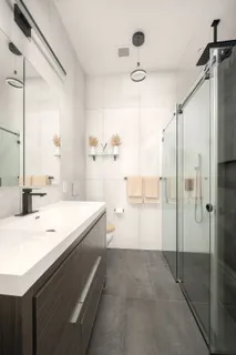 a bathroom with a sink a toilet and shower