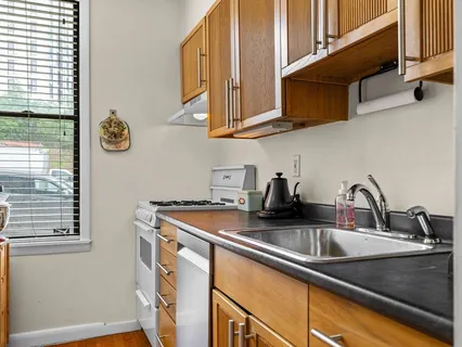 a kitchen with stainless steel appliances granite countertop a sink and a white cabinets