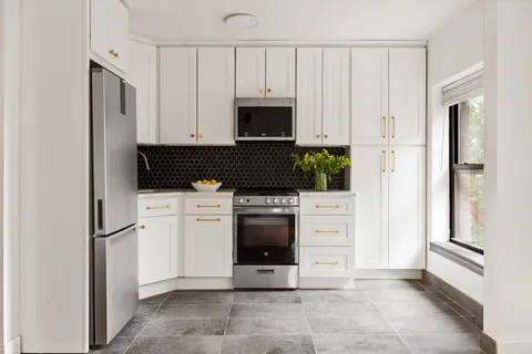 a kitchen with white cabinets and white appliances