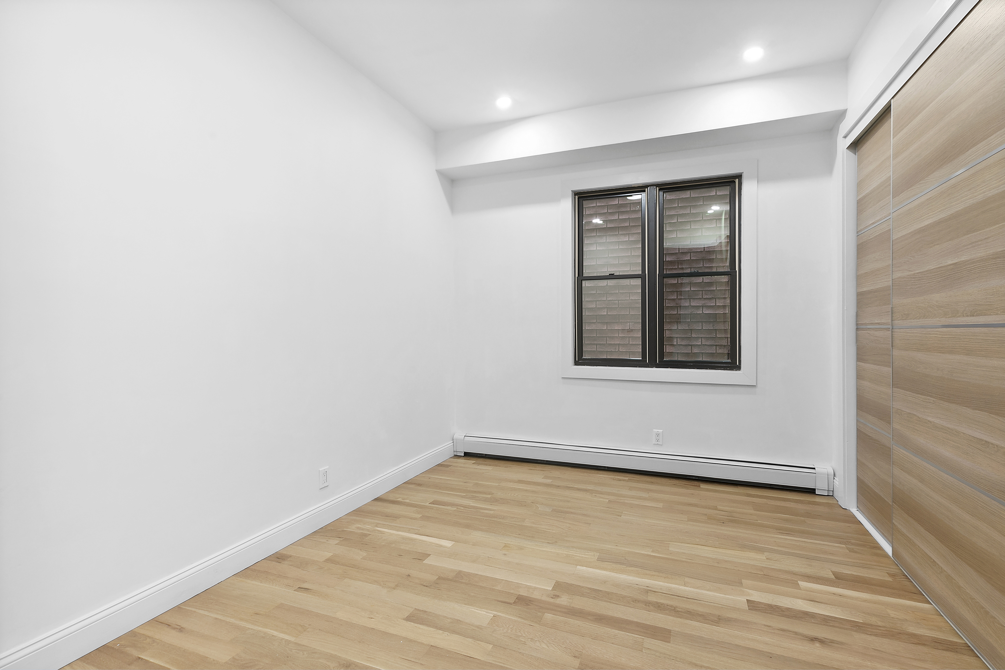 35-17 30th Street, Unit GARDEN Queens, NY 11106 - Photo 8 of 14 a view of an empty room with wooden floor and a window