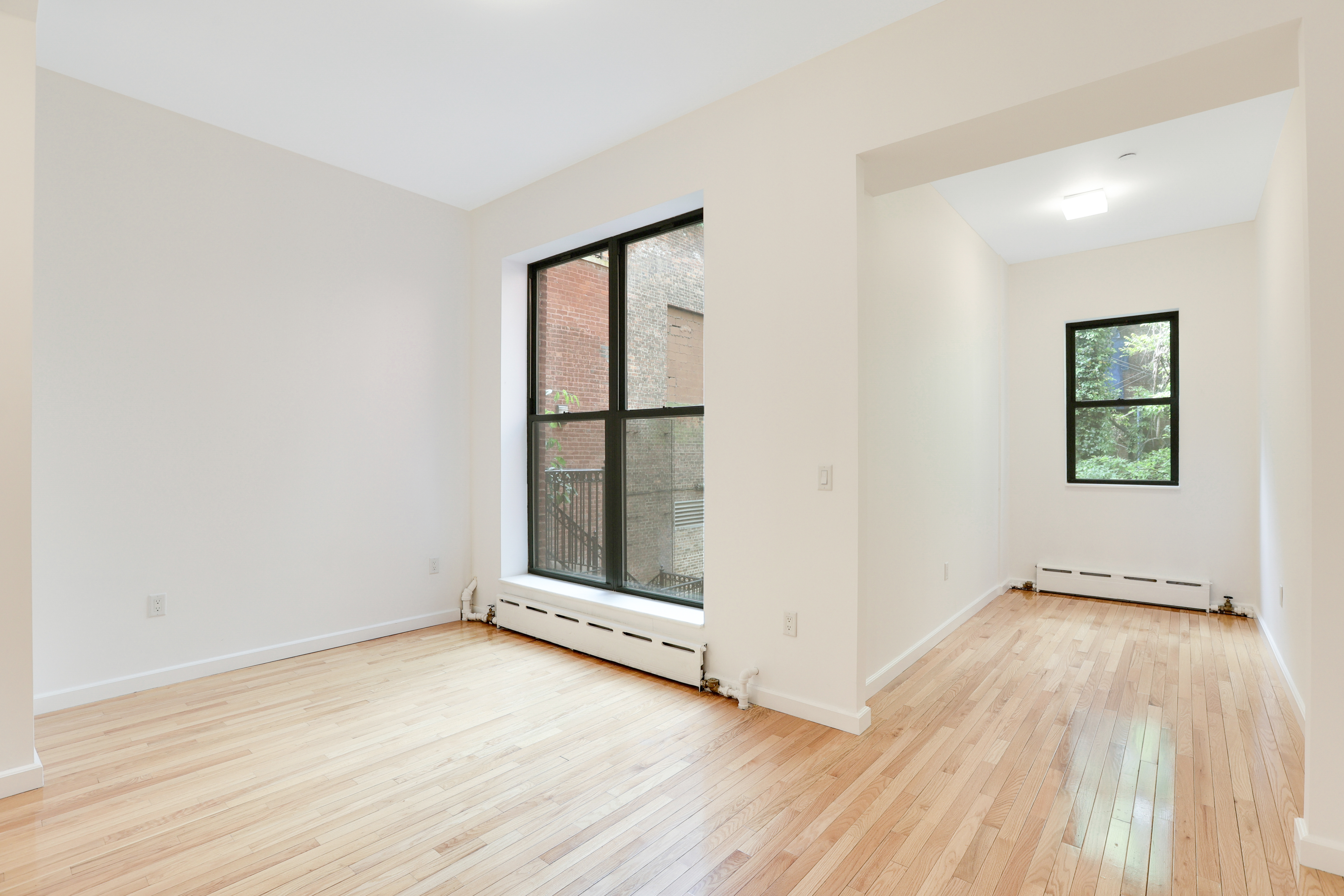 230 West 75th Street, Unit 1 Manhattan, NY 10023 - Photo 2 of 9 an empty room with wooden floor and windows