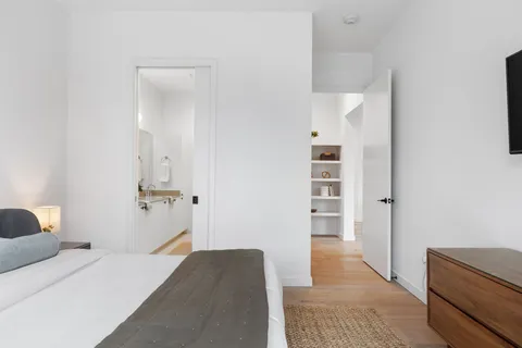 a bedroom with a bed and the view of bathroom