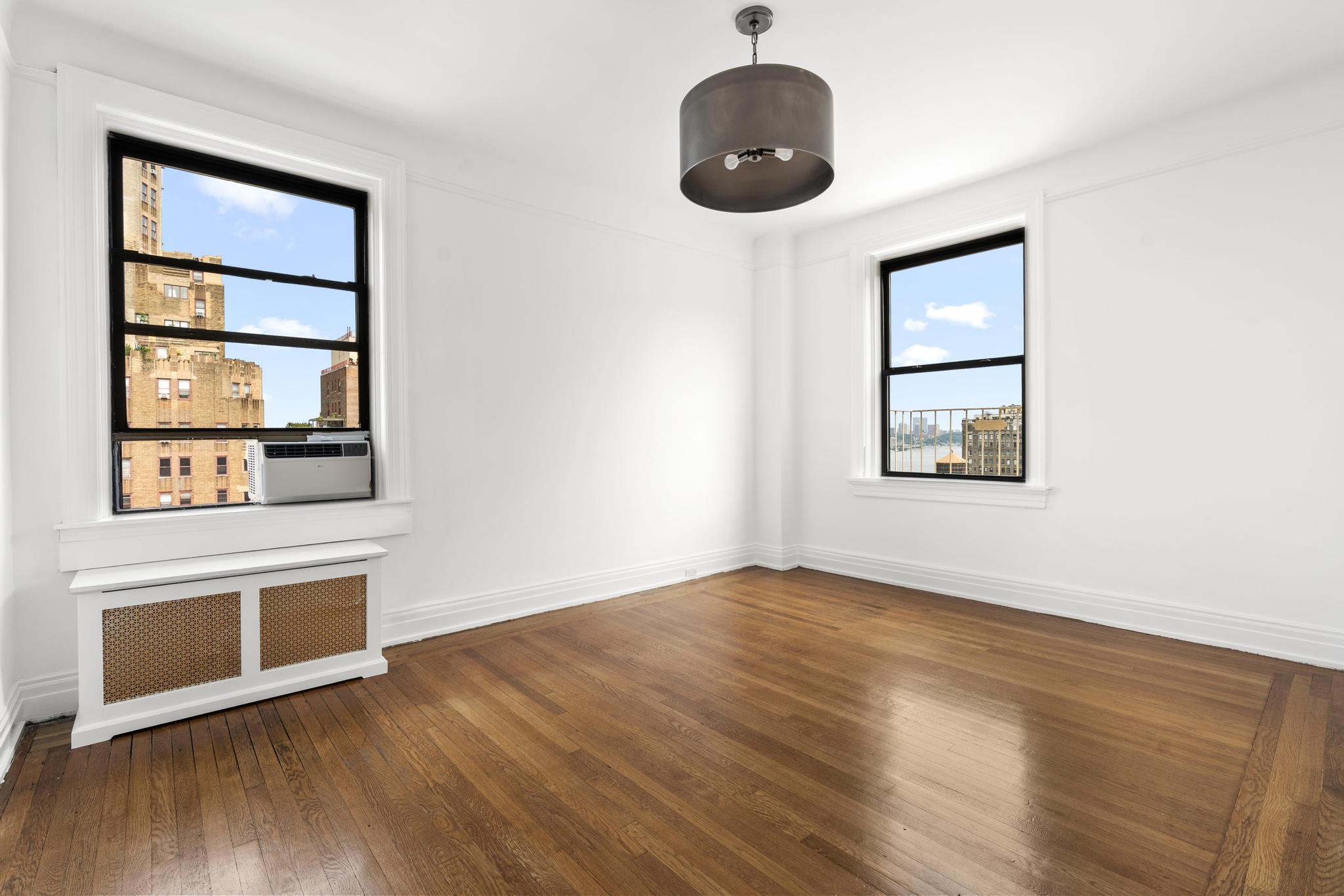 885 West End Avenue, Unit 12D Manhattan, NY 10025 - Photo 11 of 24 an empty room with wooden floor and windows