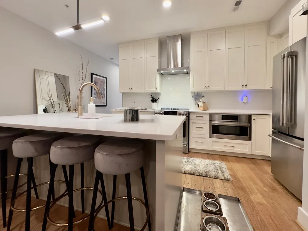 a kitchen with granite countertop a table chairs microwave and cabinets