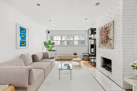 a living room with furniture a fireplace and a potted plant