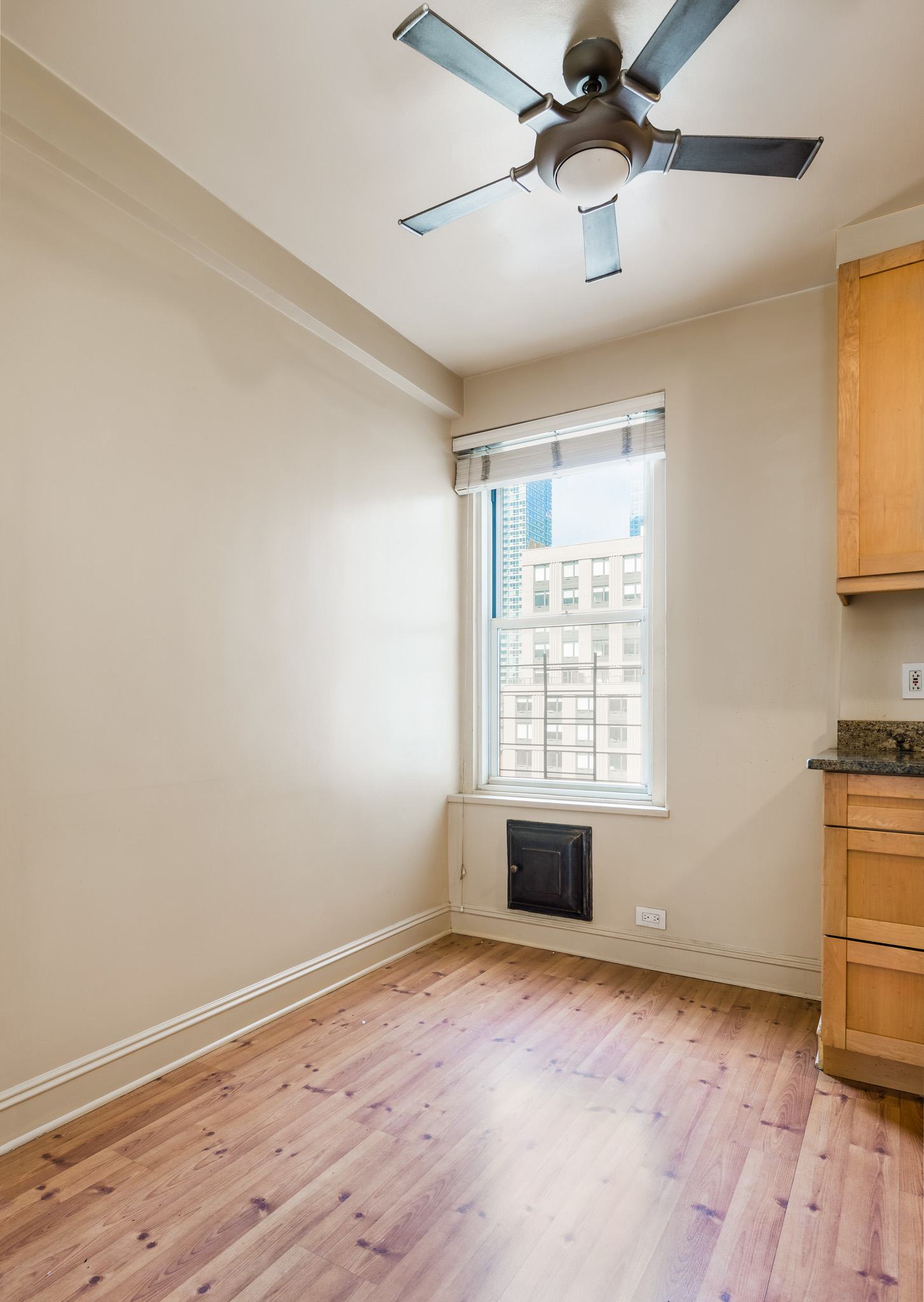 433 West 34th Street, Unit 7A Manhattan, NY 10001 - Photo 8 of 13 a view of empty room with wooden floor and fan