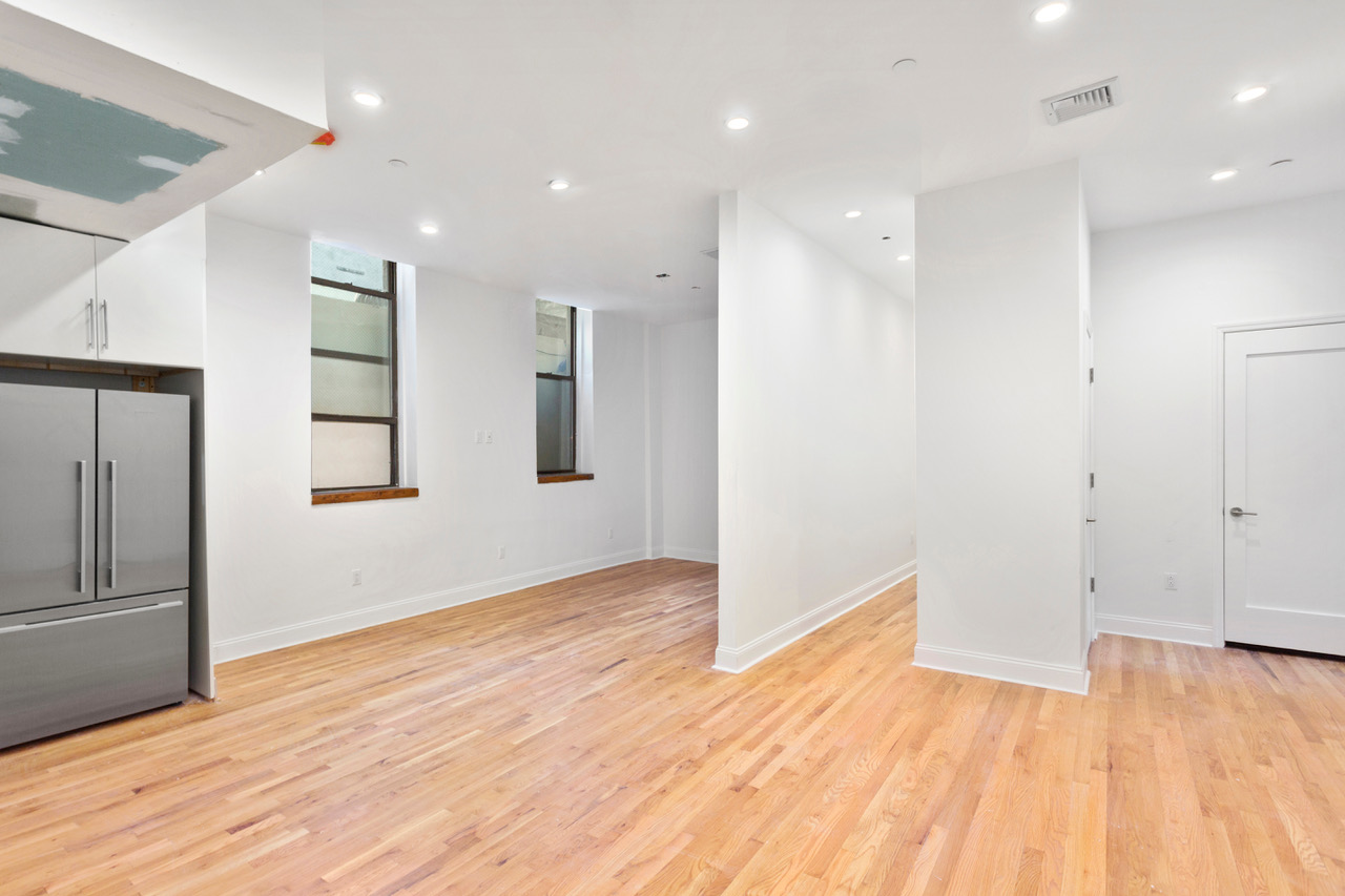 281 Grand Street, Unit 2R Manhattan, NY 10002 - Photo 4 of 11 a view of empty room with wooden floor and window