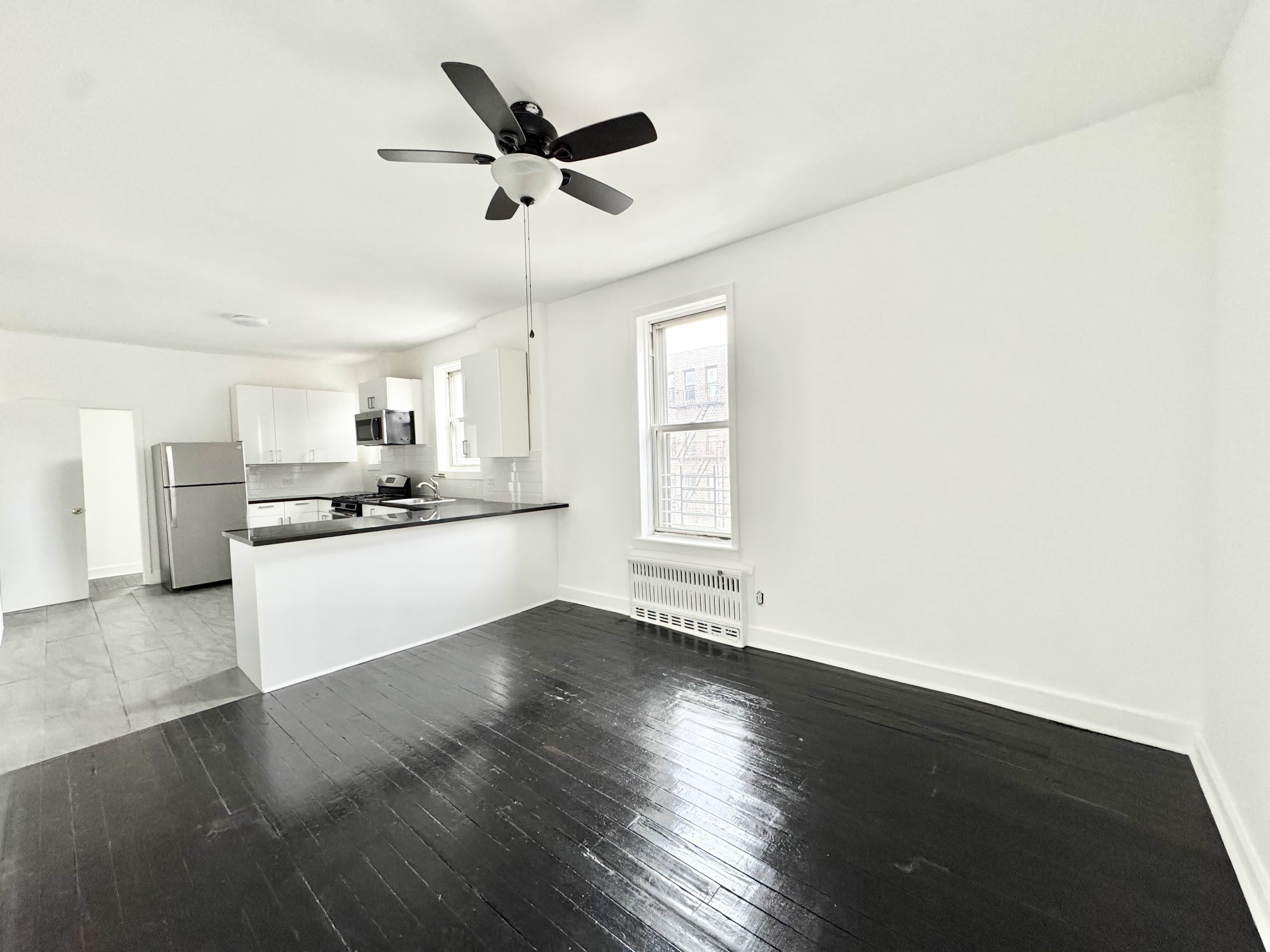 406 Rogers Avenue, Unit 3 Brooklyn, NY 11225 - Photo 3 of 9 a view of a kitchen with wooden floor and a ceiling fan