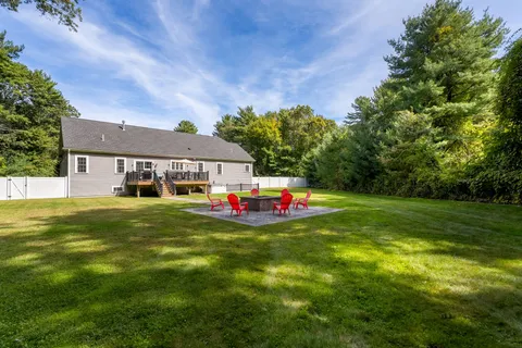 a front view of house with yard and trees in the background