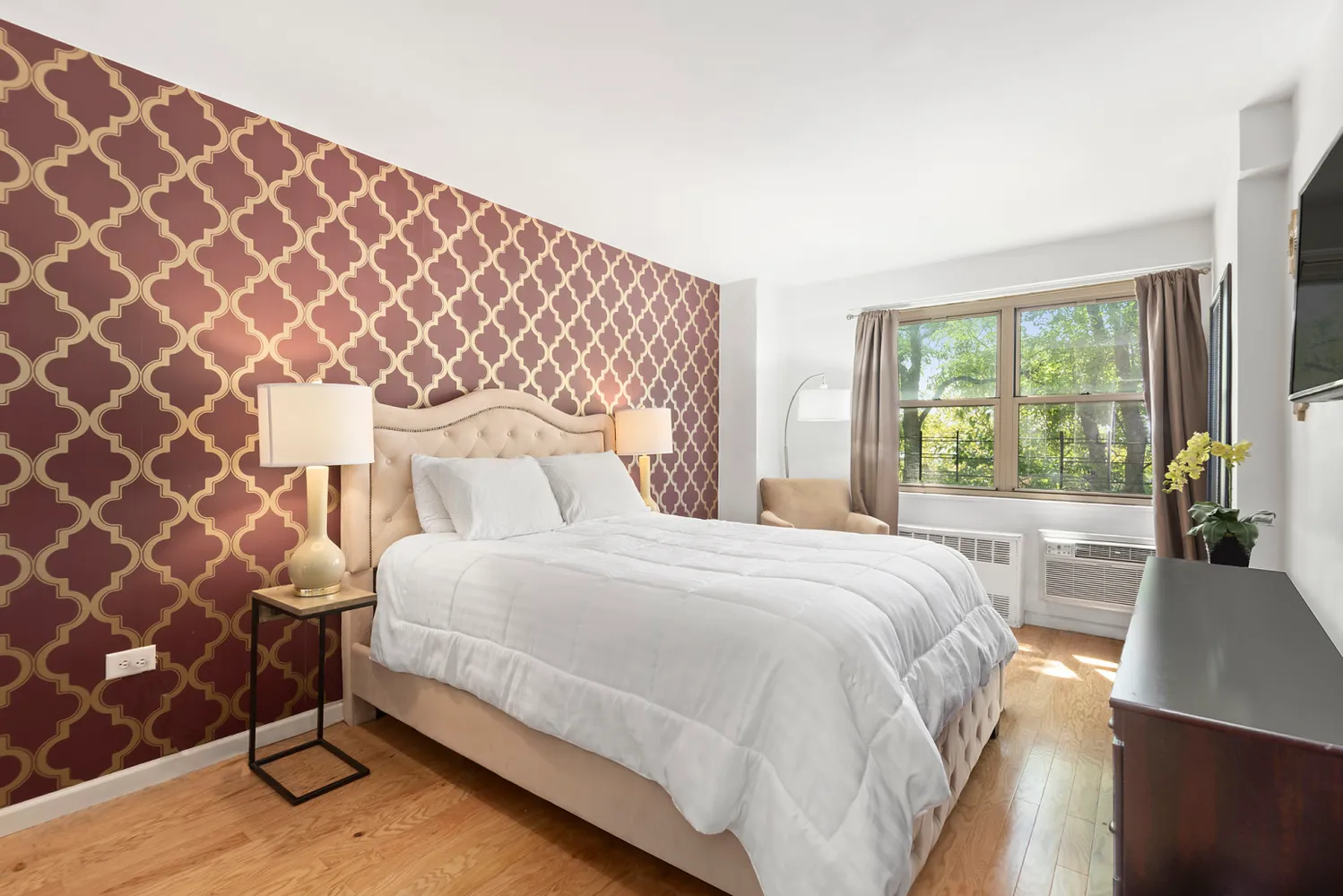 a bedroom with a bed and a lamp next to a window