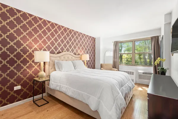 a bedroom with a bed and a lamp next to a window