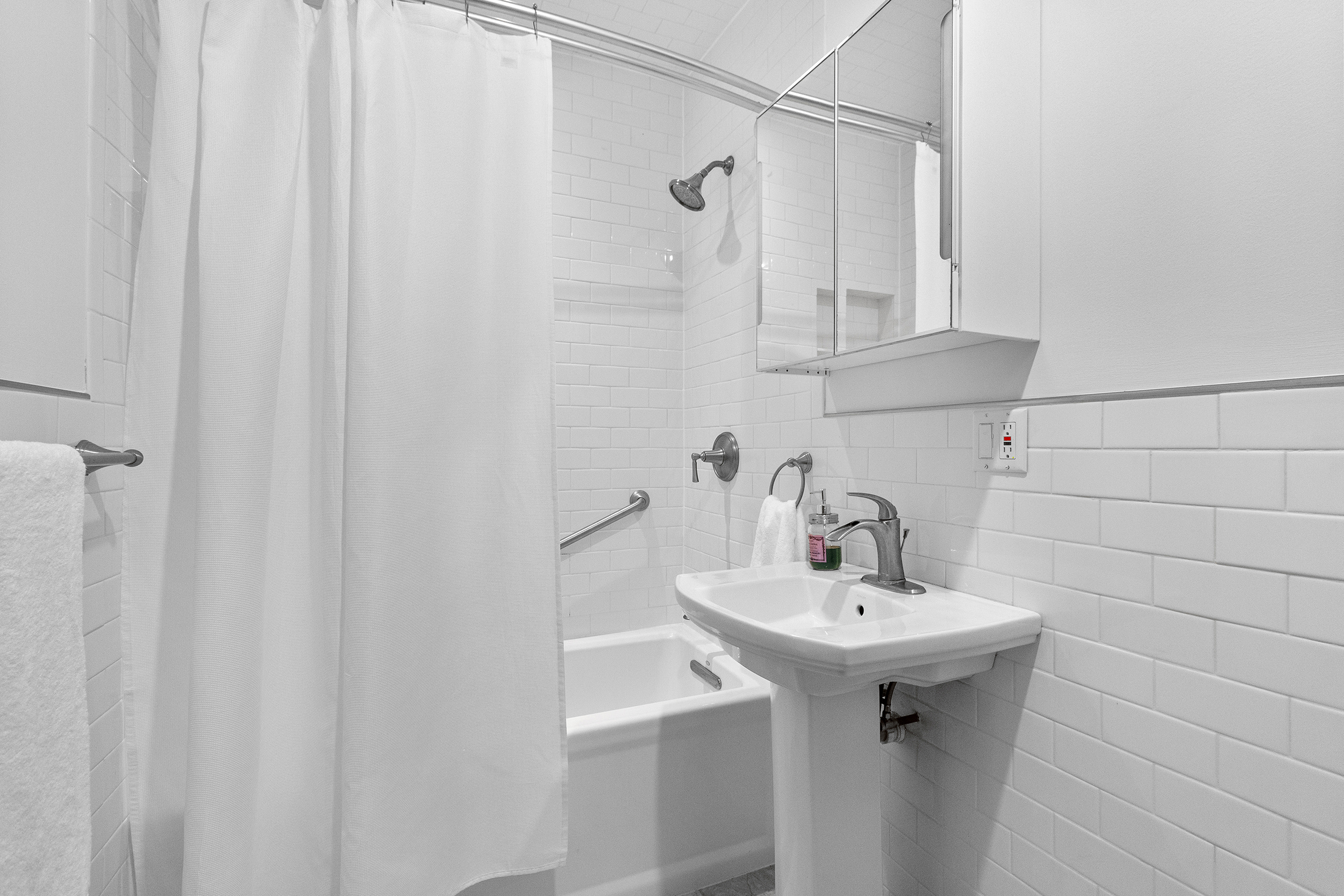 579 5th Street Brooklyn, NY 11215 - Photo 12 of 19 a bathroom with a sink a mirror and shower
