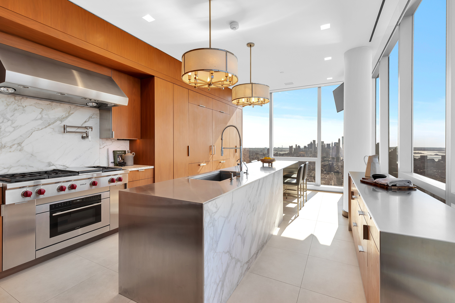 23 East 22nd Street, Unit PH Manhattan, NY 10010 - Photo 8 of 32 a large kitchen with stainless steel appliances kitchen island granite countertop a stove a sink a oven and a dining table with wooden floor
