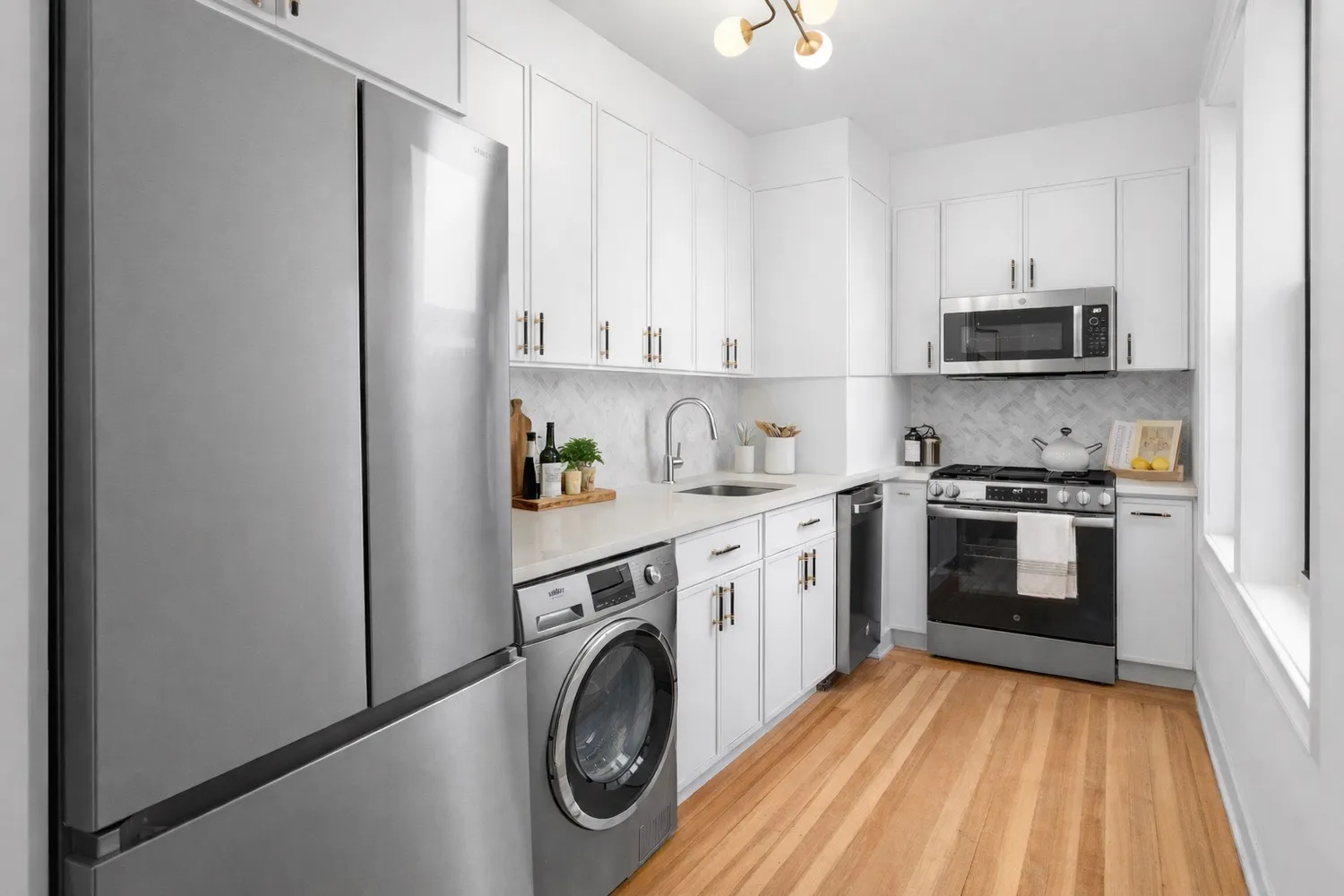 a kitchen with a refrigerator a stove top oven a sink and cabinets