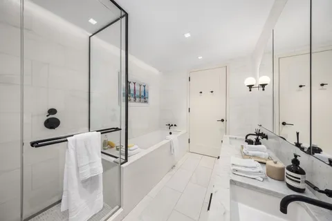 a bathroom with a tub sink and mirror
