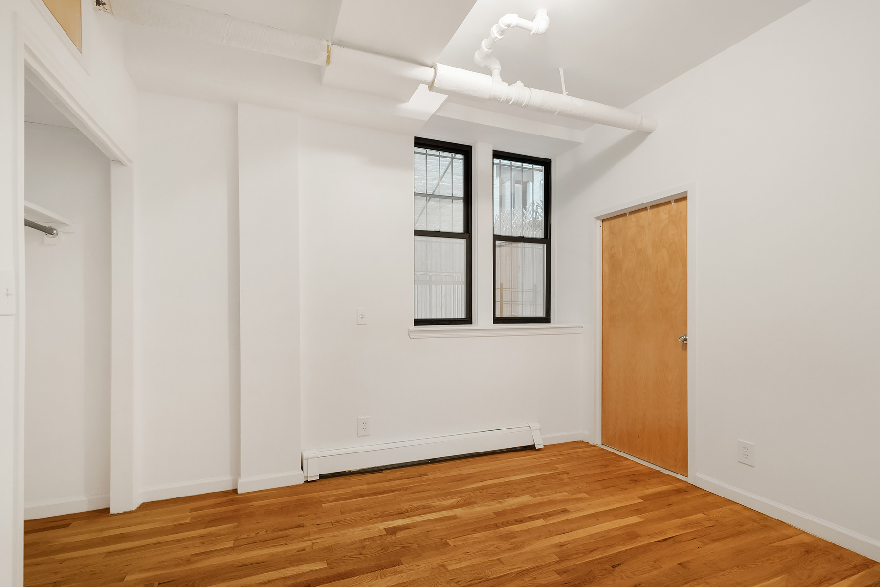 205 West 10th Street, Unit GARDEN Manhattan, NY 10014 - Photo 4 of 8 a view of an empty room with wooden floor and a window