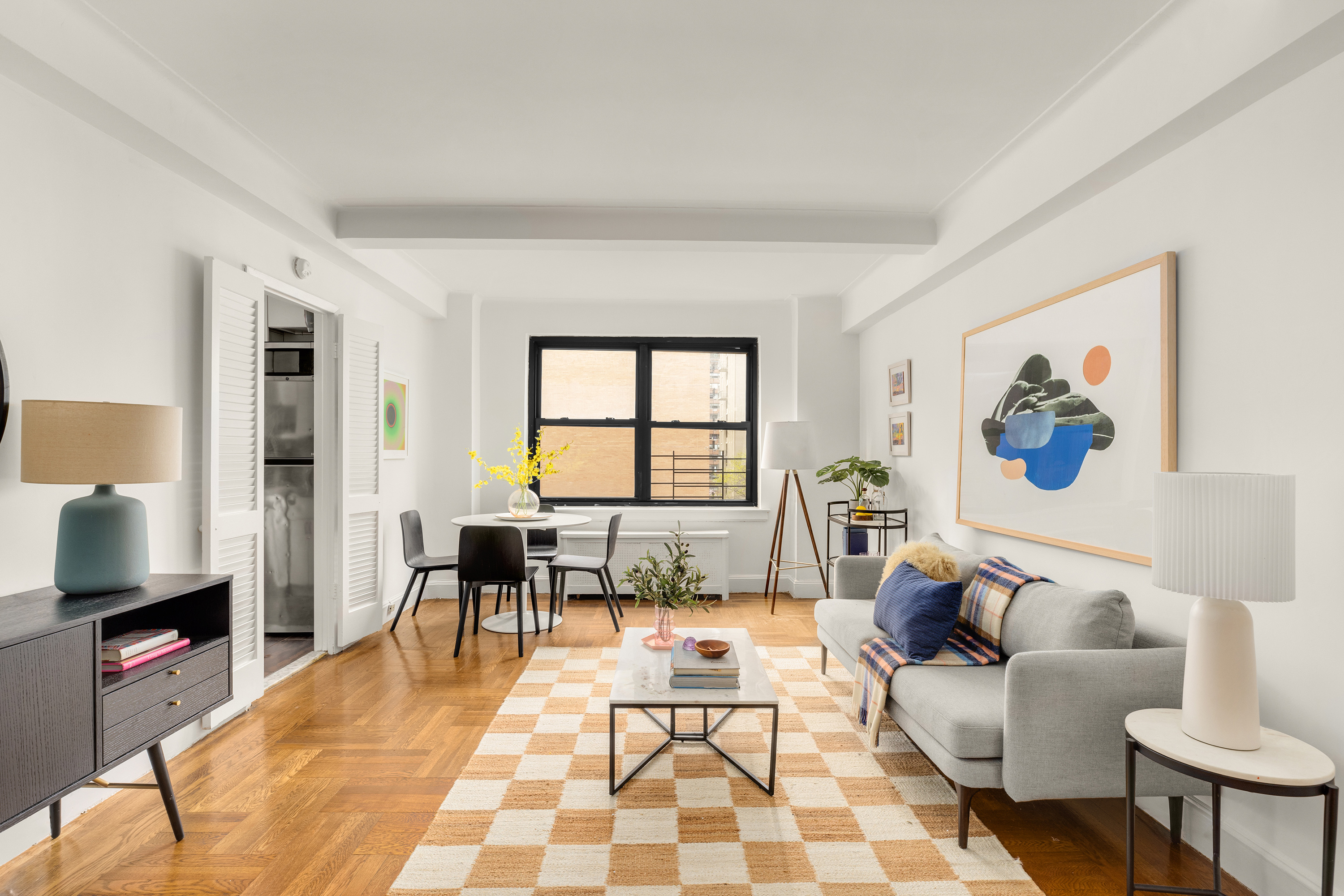 245 East 72nd Street, Unit 8G Manhattan, NY 10021 - Photo 3 of 10 a living room with furniture a flat screen tv and a window