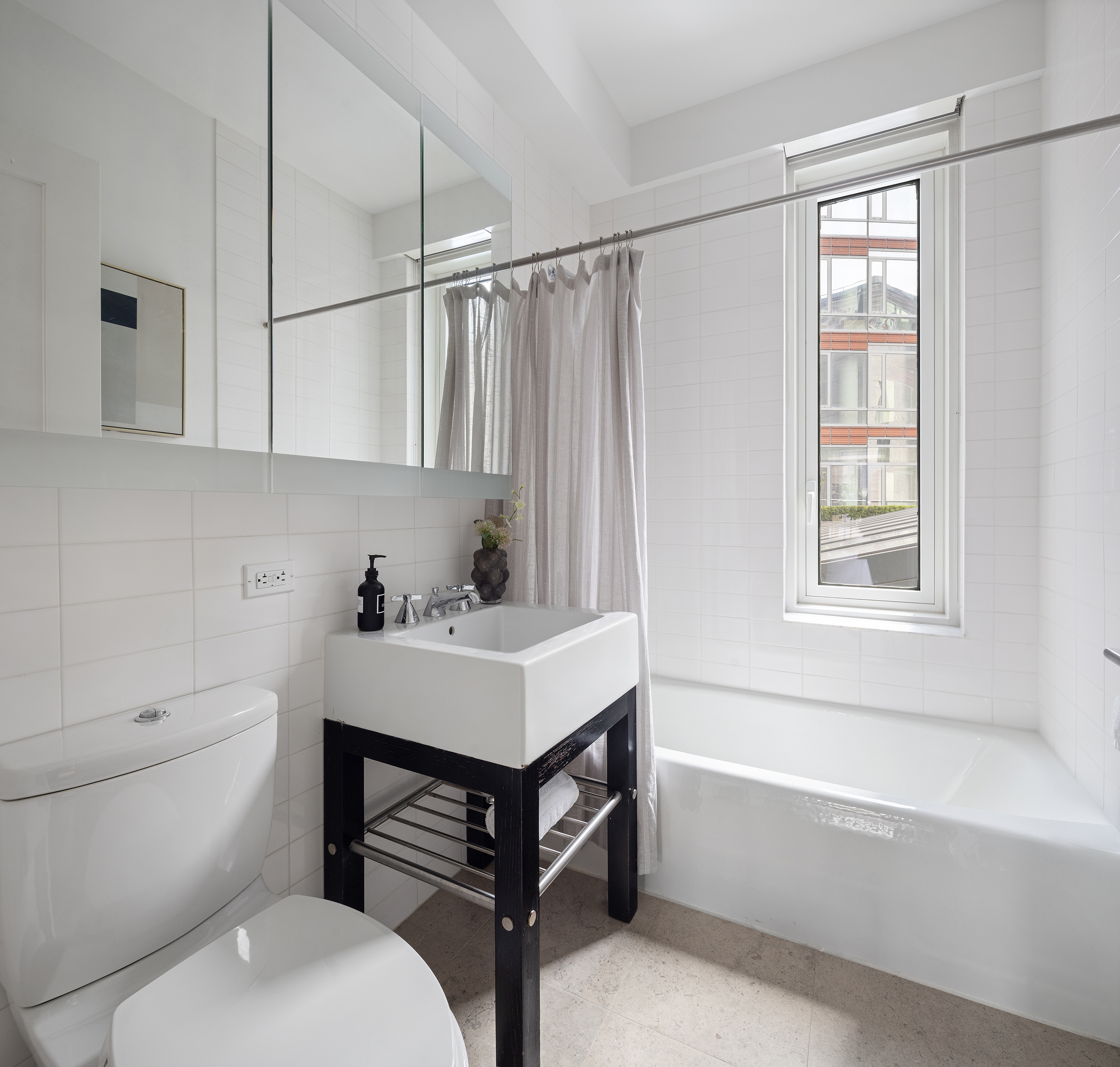 70 Little West Street, Unit 7L Manhattan, NY 10004 - Photo 19 of 25 a bathroom with a sink toilet vanity and bathtub
